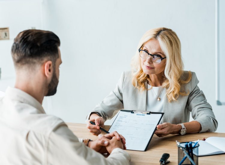 selective-focus-of-recruiter-in-glasses-holding-pen-near-clipboard-and-looking-at-bearded-man.jpg